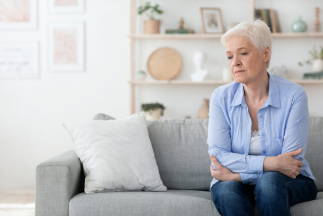 old woman sitting on couch alone