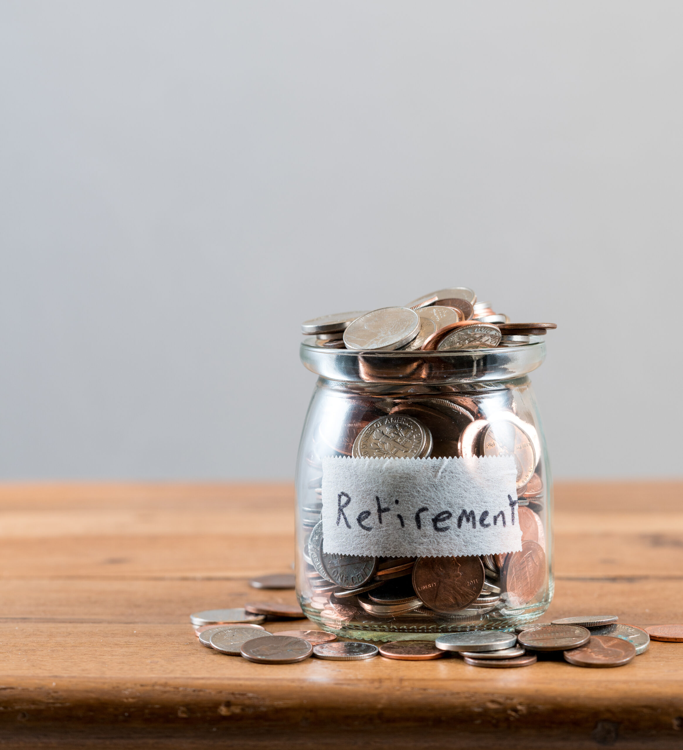 Glass savings jar full of loose change and coins retirement