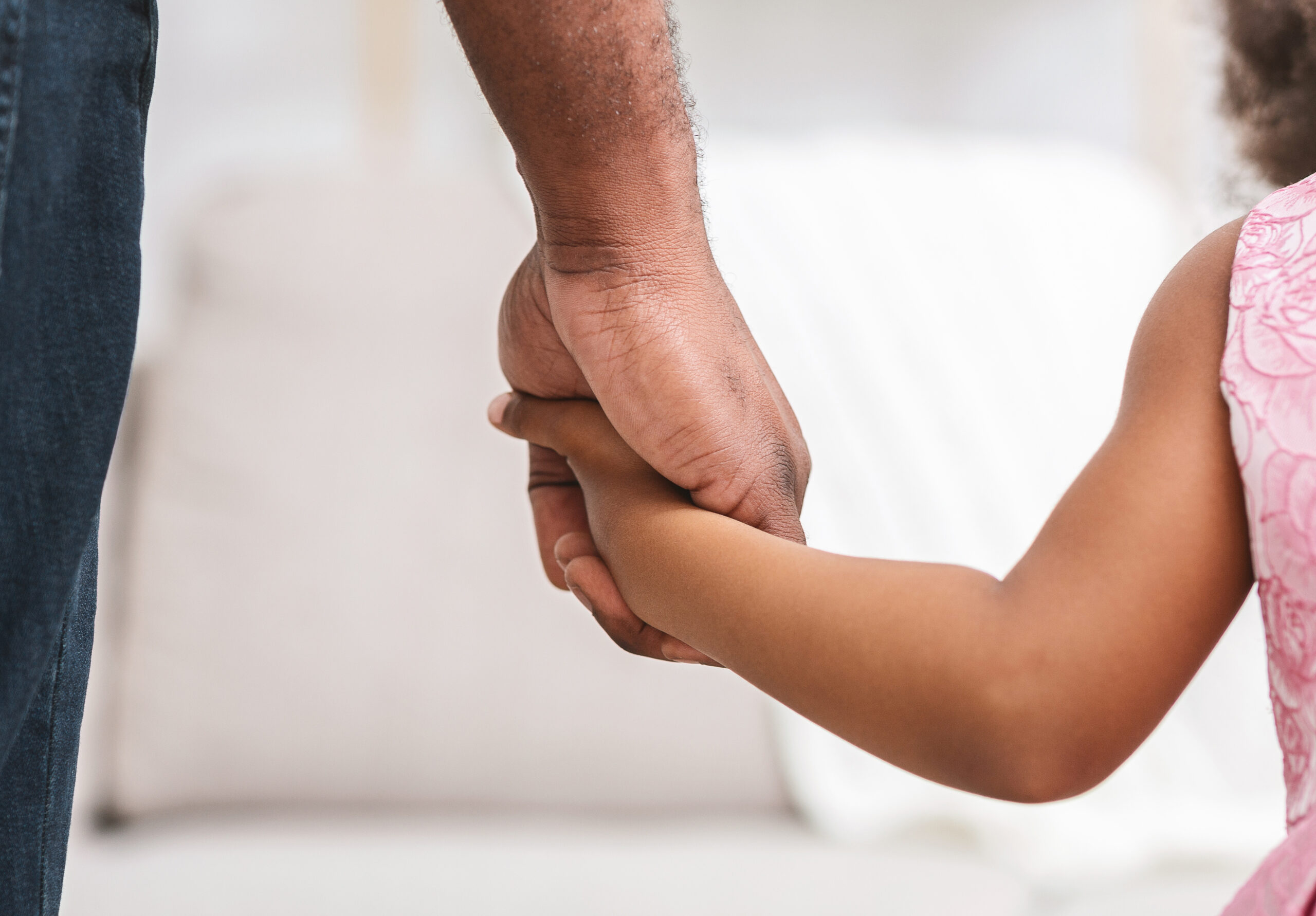Black father giving hand to his little daughter, close up, supporting, care, parenthood