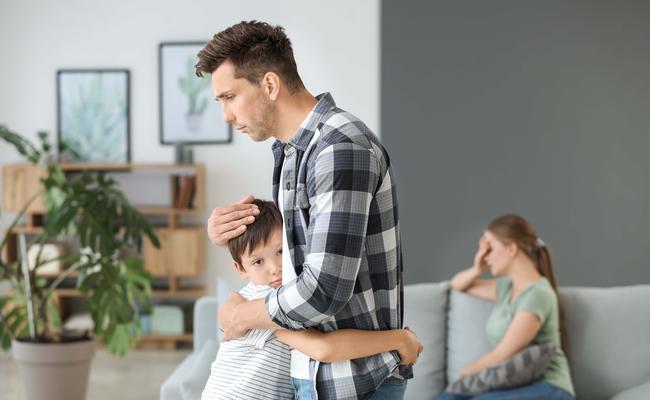 Man calming his son after family quarrel at home