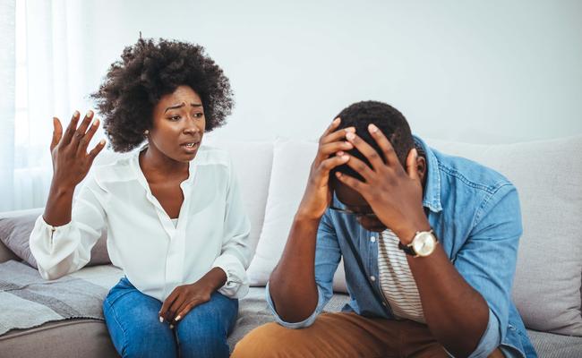 couple aruging while sitting on couch