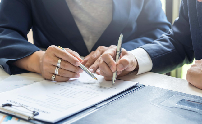 two businessmen signing contracts