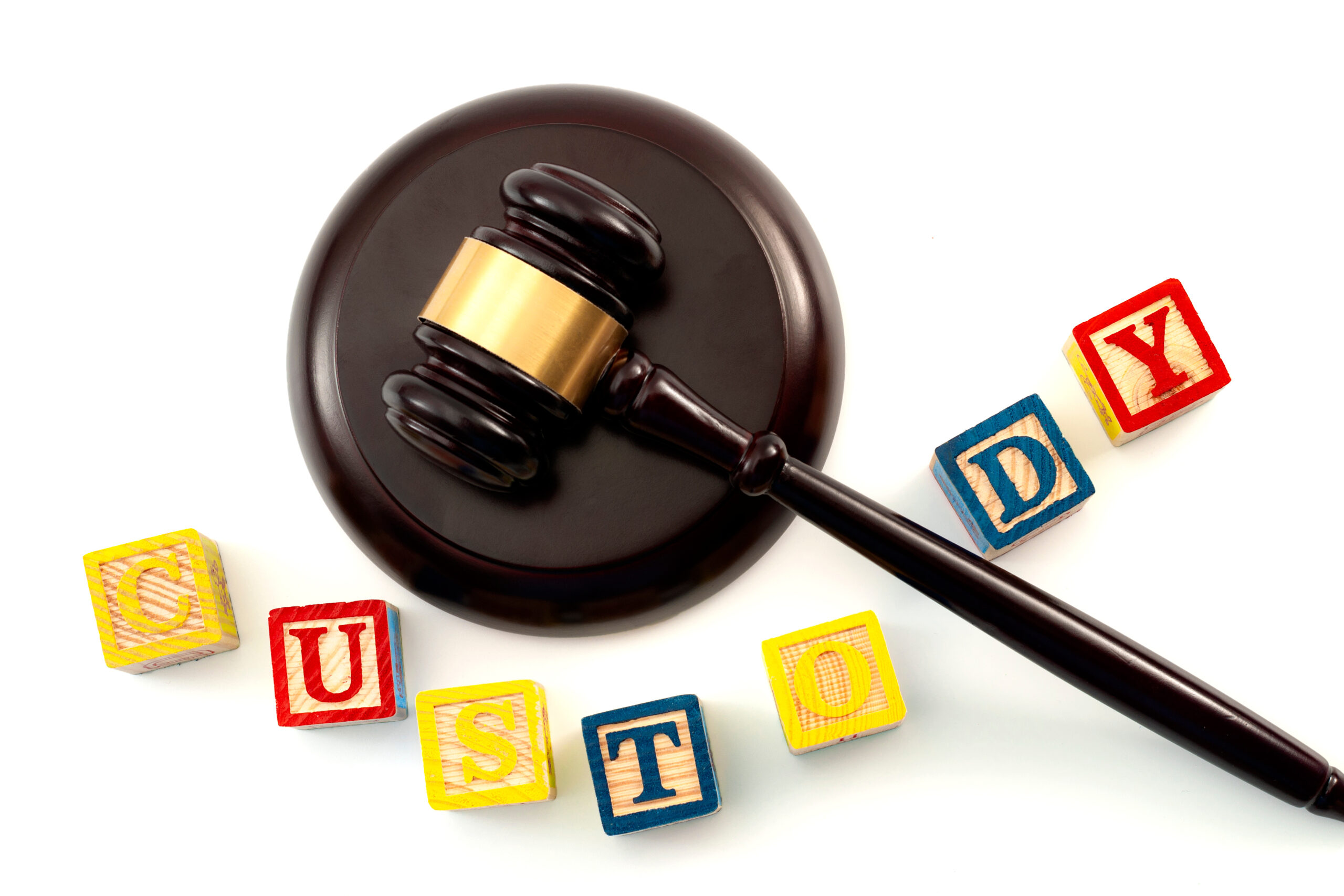 Legal decision regarding the custody of children after a divorce concept theme with close up on a wooden gavel and kids wood blocks toy with letters isolated on white background