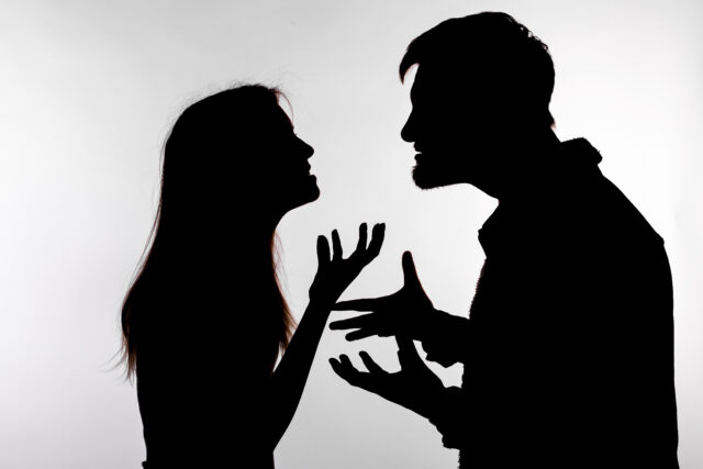 Aggression and abuse concept - man and woman expressing domestic violence in studio silhouette isolated on white background.
